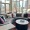 a room with large windows and a circular table and couch with colorful pillow