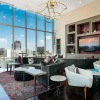 a room with large windows and maple seating options