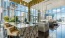 a lounge with tables seating and large windows